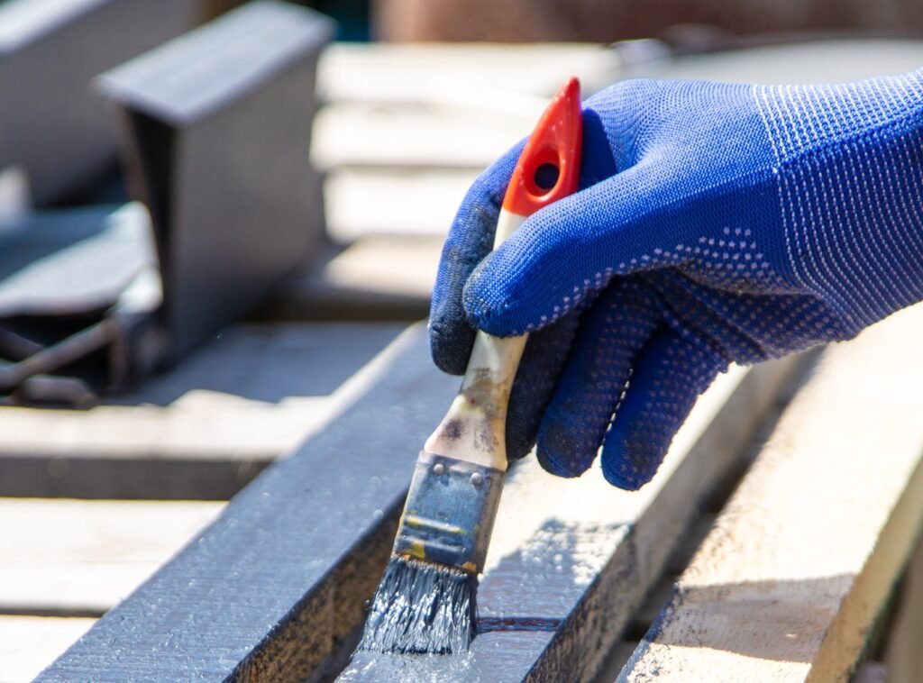 A man paints a board with paint. Selective focus.